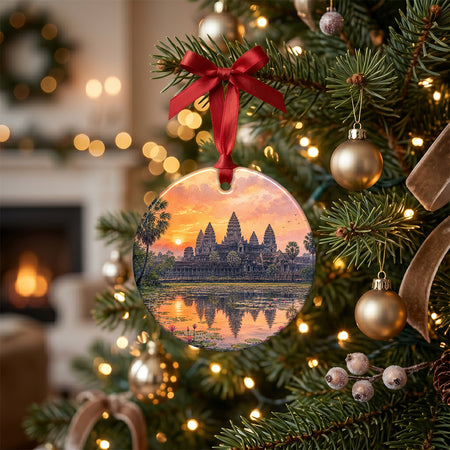 Round ceramic holiday decoration resting on a rustic table beside a seasonal pinecone and candle.