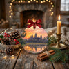 Round ceramic holiday decoration resting on a rustic table beside a seasonal pinecone and candle.