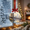 New York bridge ornament hanging in front of a frosty winter window in soft daylight.