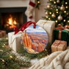 Southwest travel ornament placed beside wrapped holiday gifts near a warm brick hearth.