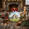Holiday ornament styled on a rustic table with pinecones and a warm candle.