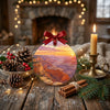 Round ceramic national park decoration placed on a rustic holiday table with pinecones and a candle.