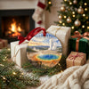 Festive Grand Prismatic Spring ornament resting next to wrapped holiday gifts near a warm fireplace.
