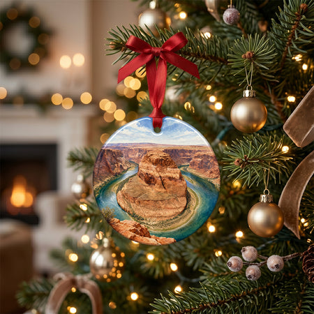 Festive desert holiday ornament styled on a rustic table alongside pinecones and a candle.
