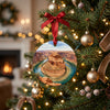 Ceramic holiday decoration hanging on a lit Christmas tree branch in a festive room.
