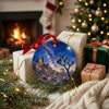 Round ceramic holiday decoration resting near festive wrapped gifts beside a warm, glowing fireplace.