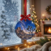 Desert scene ornament suspended in front of a frosty window during a gentle winter morning.