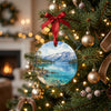 Watercolor Lake Tahoe ornament hanging gracefully on an illuminated Christmas tree branch.