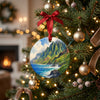 Ceramic Kauai ornament hanging among glowing holiday lights on a Christmas tree branch.