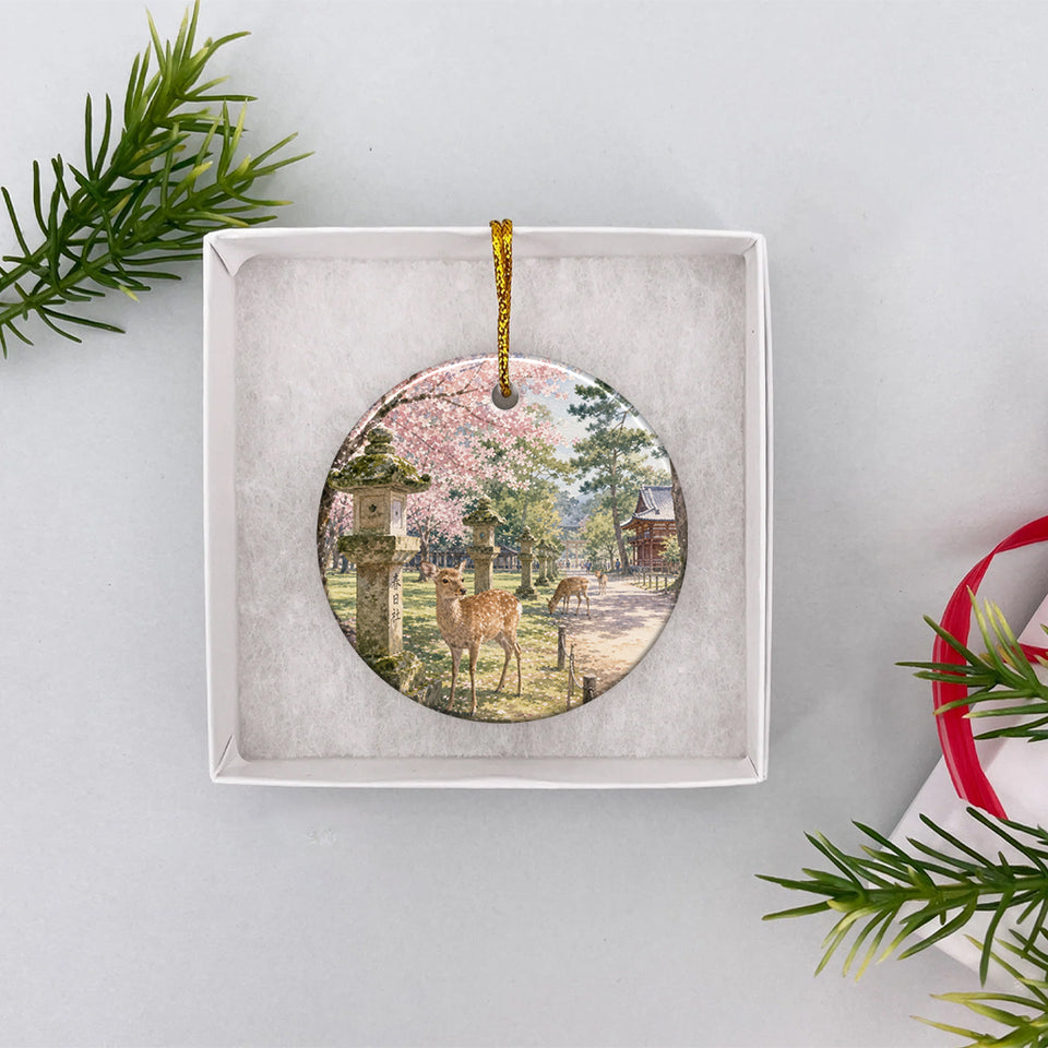 Round travel ornament packaged inside an opened white gift box ready for holiday gift giving.