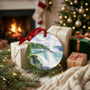 Double-sided ceramic waterfall ornament displayed beside wrapped holiday gifts near a glowing fireplace.