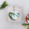 Round Niagara Falls holiday ornament nestled neatly inside an open white gift box ready for gifting.