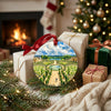 Double-sided Versailles landscape ornament sitting beside wrapped gifts in front of a warm holiday hearth.