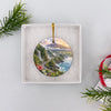 Hawaiian volcanic landscape ornament nestled inside an open white gift box packaging.