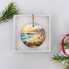 Ceramic coastal pier ornament presented inside an open white gift box ready for holiday giving.