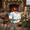 Holiday travel ornament displayed on a rustic tabletop beside winter pinecones and a candle.
