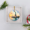 Round ceramic Statue of Liberty souvenir nestled inside an opened white gift box.