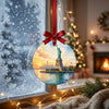 Harbor landmark ornament suspended in front of a frosty winter window in soft daytime light.