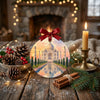 Holiday travel ornament arranged on a festive dining table next to natural pinecones and candle.