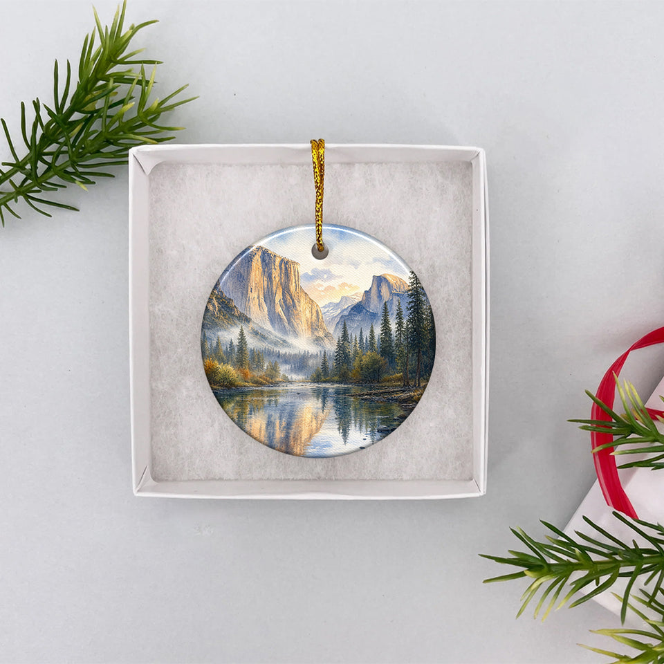 Double-sided Yosemite Valley ceramic holiday ornament presented inside an open white gift box.